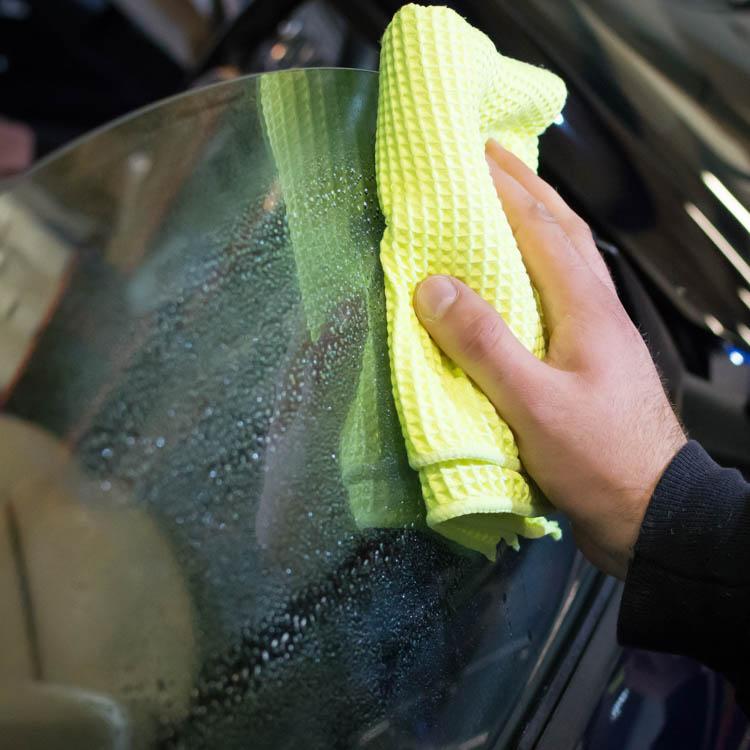 Stoner Invisible Glass With Rain Repellent being wiped with a glass cloth