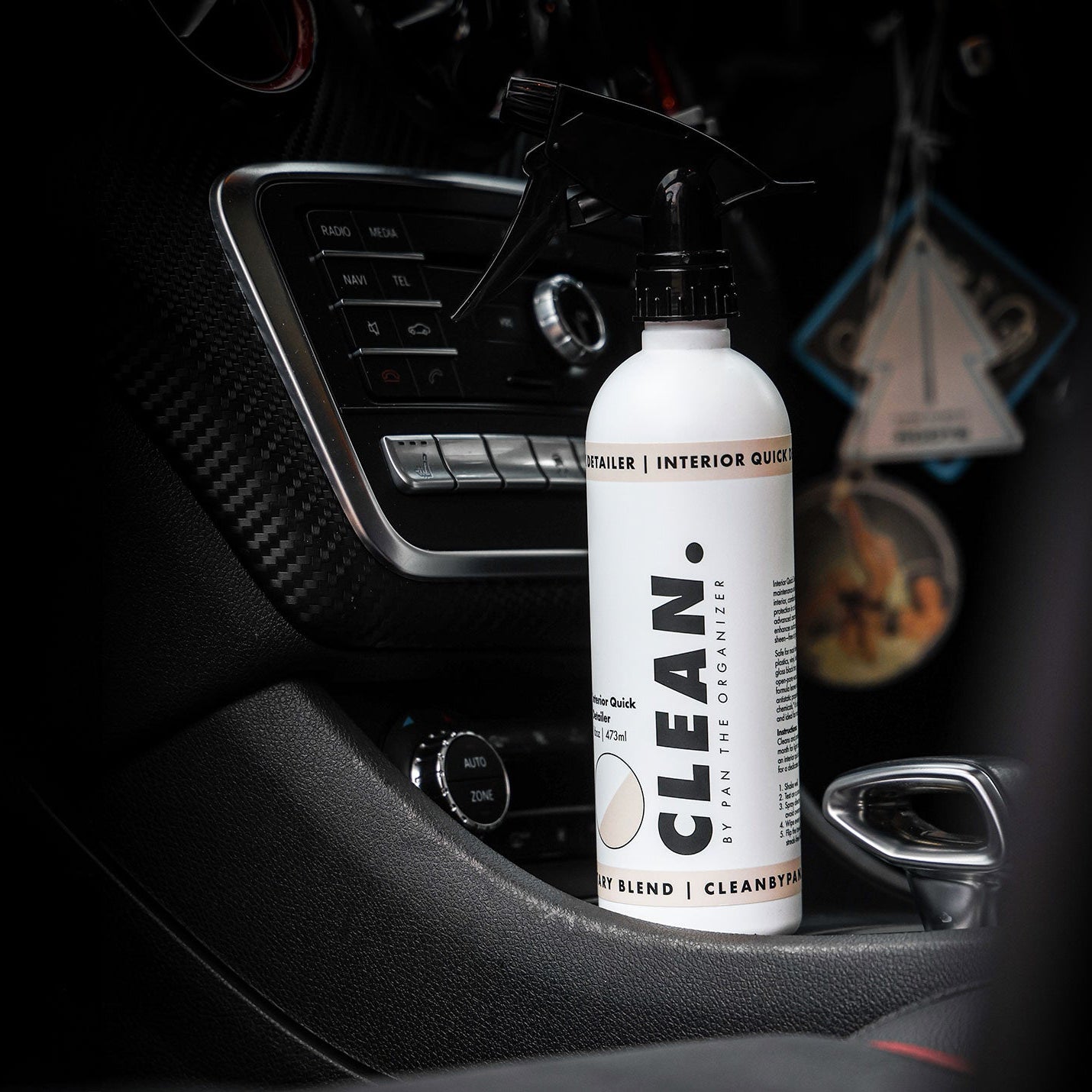 CLEAN. by Pan interior cleaner bottle with a spray nozzle inside a car.